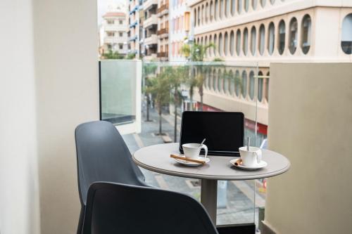 a table and chairs with a laptop on a balcony at Hotel Adonis Capital in Santa Cruz de Tenerife