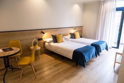 a hotel room with two beds and a table at Hotel Adonis Capital in Santa Cruz de Tenerife