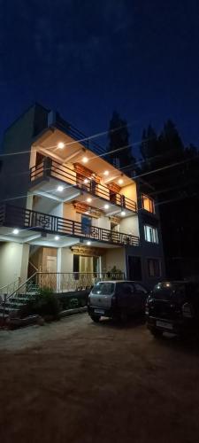 un edificio con coches aparcados delante de él por la noche en Zlatan Guest House en Leh