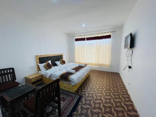 1 dormitorio con 1 cama y TV en Zlatan Guest House, en Leh