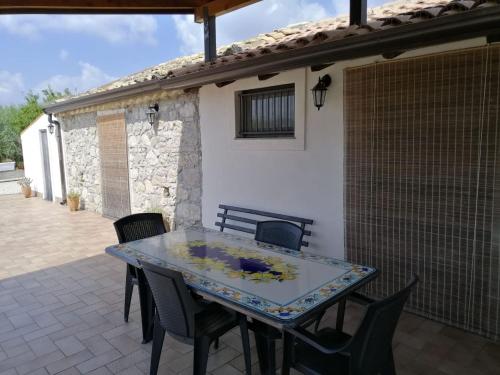 a glass table and chairs on a patio at La casa degli ulivi in Centuripe