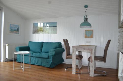 - un salon avec un canapé bleu et une table dans l'établissement Brigg im Schiffehaus, à Wangerland