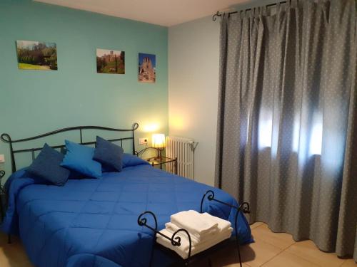 a bedroom with a blue bed with blue pillows at Hostal Can Massot in Anglés