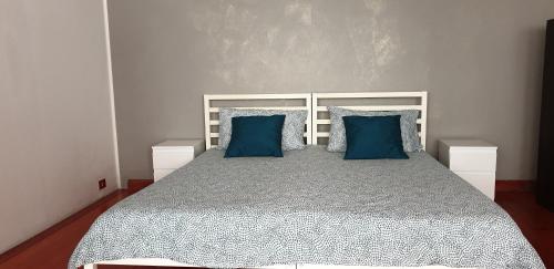 een slaapkamer met een groot bed met blauwe kussens bij Alfa Appartamento in centro in Gorizia