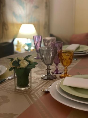 une table avec des assiettes et des verres à vin dessus dans l'établissement Dimora Storica La Corte Delle 4 Stagioni, à Ozzano Monferrato