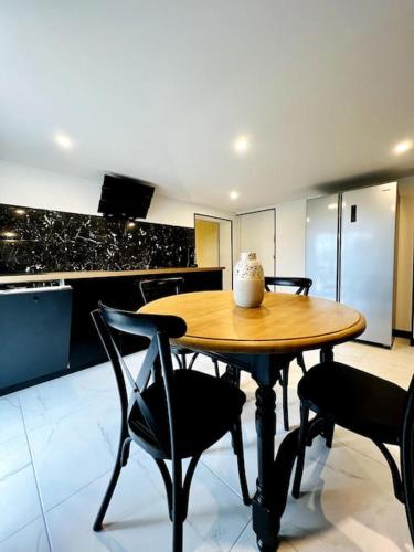 - une table et des chaises en bois dans la cuisine dans l'établissement La Suite Saint Roch, à Villeréal