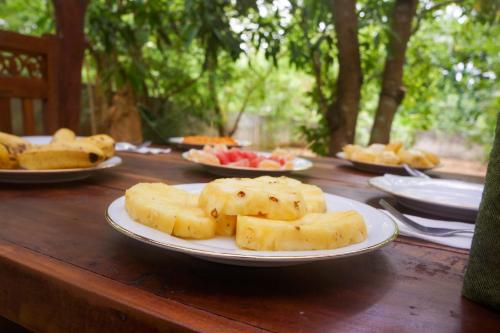 a wooden table with plates of food on it at Flash Rock Villa in Sigiriya