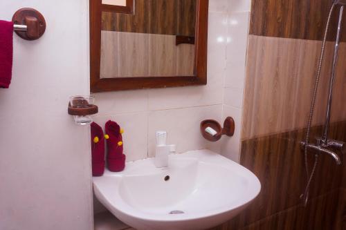 a bathroom with a sink and a mirror and red shoes at Flash Rock Villa in Sigiriya
