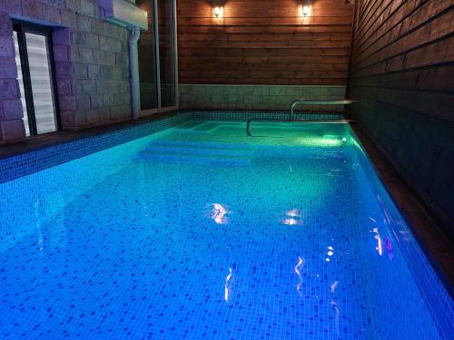 a swimming pool with blue water in a house at וילה שחר בגולן in Mas'ade