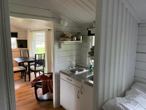 a small kitchen with a sink in a tiny house at Stuga med panoramautsikt, paradis för fågelskådare och vandrare, självstäd efter besök in Mörbylånga