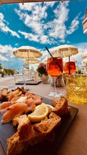 a plate of food on a table with two drinks at Hotel Eden in Sirmione