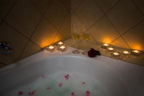 una vasca da bagno con 2 bicchieri di vino e candele di Hotel Hvar a Jelsa (Gelsa)