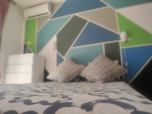 Un dormitorio con una cama con una pared azul y verde en Apartamento Turistico Dct. Creus en Guadalajara