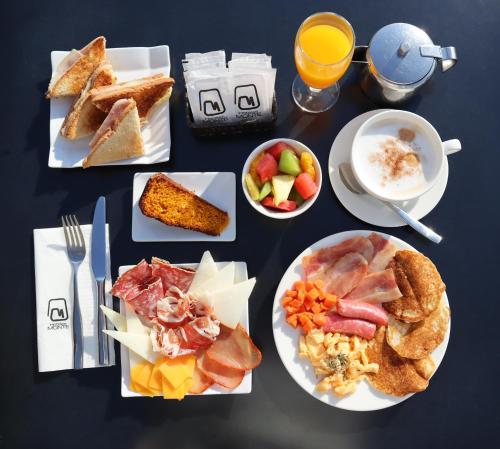 a table topped with plates of food and bowls of fruit at Monte Triana in Seville