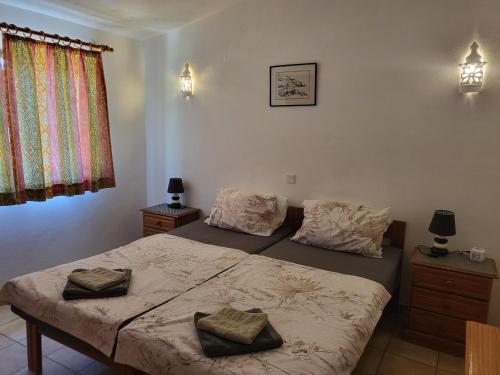 1 dormitorio con 2 camas y ventana en Feliz Apartments, en São Bartolomeu de Messines