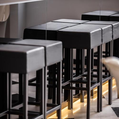 a row of black tables and stools in a room at Monte Triana in Seville