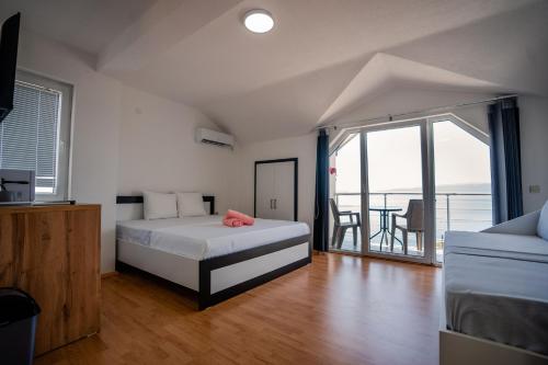 a bedroom with a bed and a balcony with a table at VILA PUPA, Elešec 2 in Ohrid