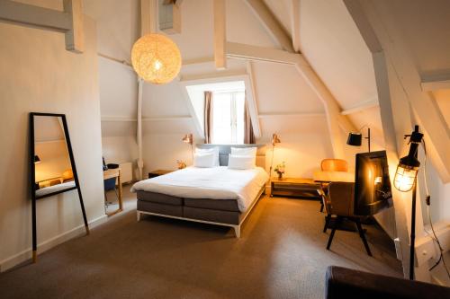 a bedroom with a bed and a desk and a mirror at Landgoed Rhederoord nabij Arnhem in De Steeg