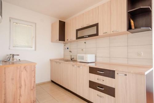 a kitchen with wooden cabinets and a sink at VILA PUPA, Elešec 2 in Ohrid