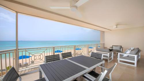 a balcony with a table and chairs and the ocean at Laguna Del Mar in George Town