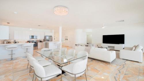 a living room with a glass table and white chairs at Laguna Del Mar in George Town
