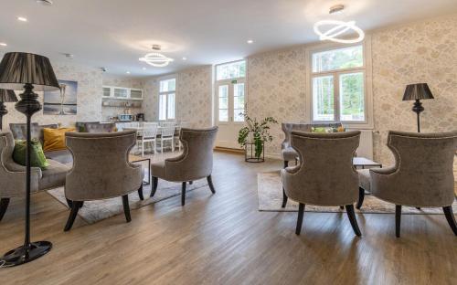 a living room with chairs and a dining room at Radalla Resort in Kausala