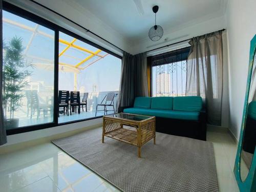 a living room with a blue couch and a table at Saba 502, Subko Coffee, Chapel Road, Bandra West by Connekt Homes in Mumbai