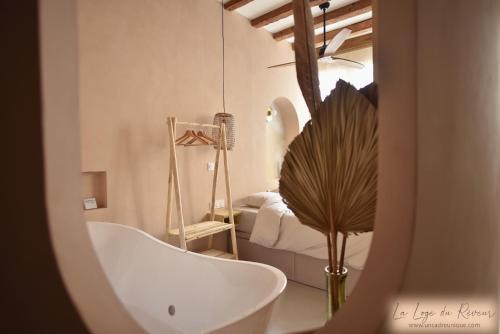 a bathroom with a bath tub and a bedroom at La Loge du Rêveur - Spa - Vieux-Lyon in Lyon