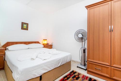 a bedroom with a bed and a closet and a fan at Vacation Flat w Garden Patio BBQ in Mugla in Mugla
