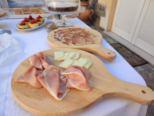 two wooden cutting boards with meat and cheese on a table at Bigotti in Fano