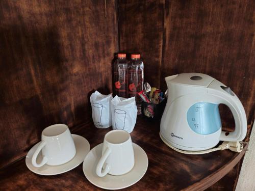 a counter with two cups and a toaster on it at Baan Panwa Resort in Panwa Beach
