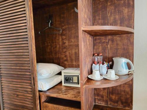a small room with a bed and a microwave at Baan Panwa Resort in Panwa Beach