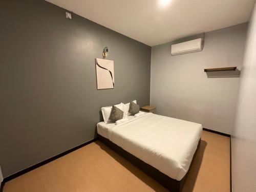 a small bedroom with a bed with white sheets at The Sky Inn in Kuantan