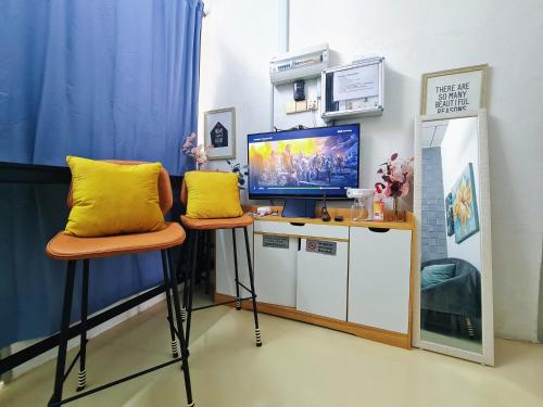 a room with two stools with a desk with a television at Cozy n Quiet home near to BKE Highway n Kulim High Tech Park in Lunas