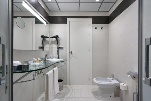 a white bathroom with a sink and a toilet at Monte Triana in Seville