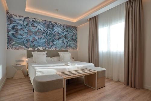 a bedroom with a large white bed and a window at Monte Triana in Seville