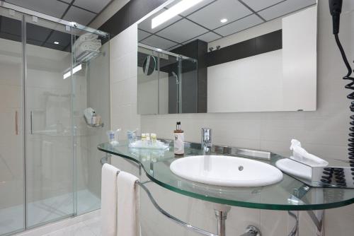 a bathroom with a glass sink and a shower at Monte Triana in Seville