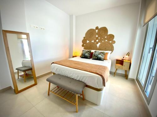 una camera con letto, specchio e sedia di MyChoice Frida by Bossh! Apartments a Rota