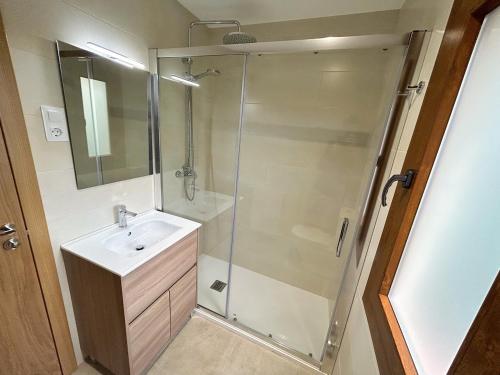 a bathroom with a glass shower and a sink at Apartament familiar amb vistes i cèntric by RURAL D'ÀNEU in Esterri d'Àneu