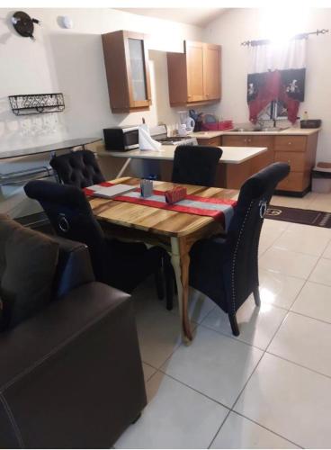 a kitchen with a wooden table and chairs in it at Leila VIllage Plus in Mendes