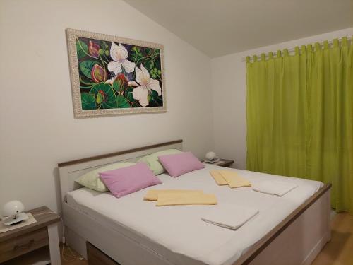 a bedroom with a large bed with a green curtain at Apartment Roglić in Rab