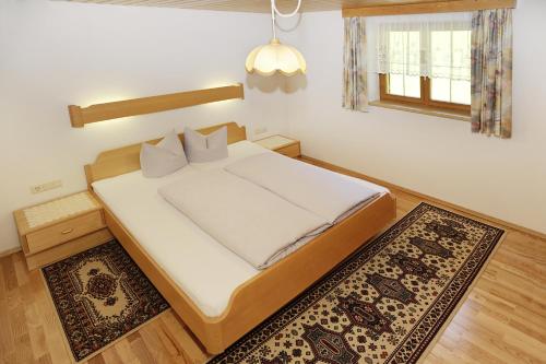 a bedroom with a bed and a rug at Haus Obere Allmein in Sankt Gallenkirch