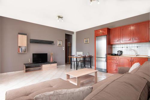 a living room with a couch and a kitchen at Theoni’s country house with garden and sea view in Alexandroupoli