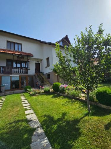 a house with a tree in the yard at Юндовата къща in Beli Iskar