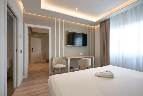 a bedroom with a bed and a table with chairs at Monte Triana in Seville