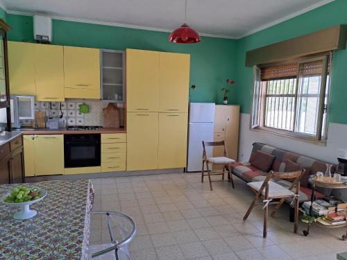 een keuken en een woonkamer met gele kasten en een bank bij Villino Relax in Portopalo