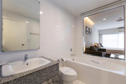 a bathroom with a sink and a toilet and a mirror at Kantary 304 Hotel Prachinburi in Si Maha Phot