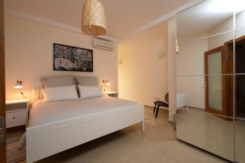 um quarto com uma cama branca e um espelho em Brand new listing located just off Sliema seafront em Sliema