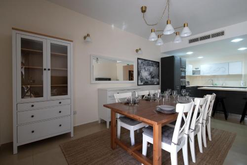 uma sala de jantar com uma mesa de madeira e cadeiras brancas em Brand new listing located just off Sliema seafront em Sliema