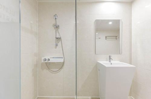 a bathroom with a shower with a toilet and a sink at Wonju Central Hotel in Wonju